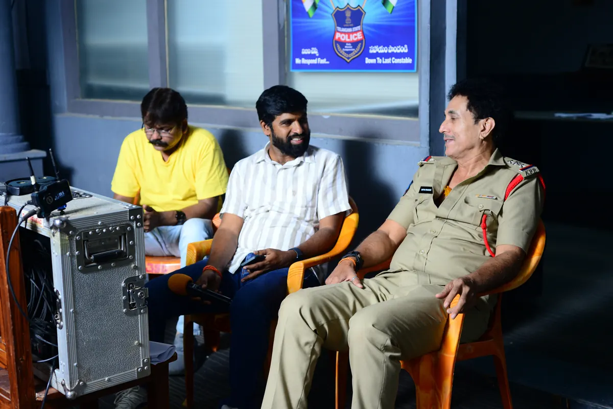 Jai Jnana Prabha Thota in conversation with an actor in police uniform on set