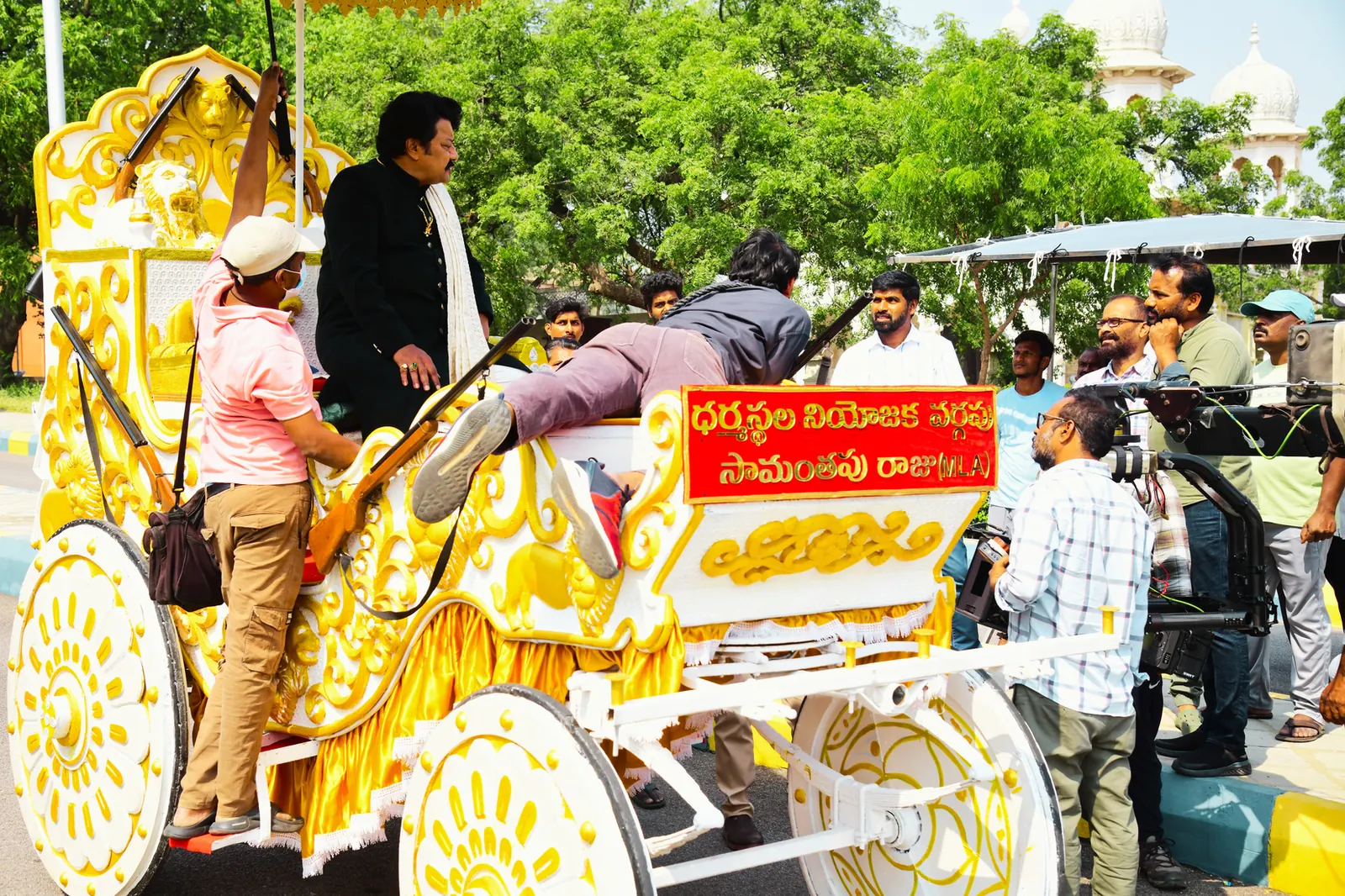 Film crew shooting a scene around a decorated golden chariot